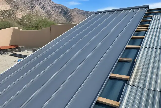 Standing seam and corrugated metal roofing installation on a sloped roof in Tucson, AZ.