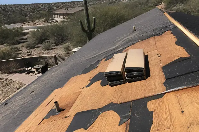 Repairing storm damage with missing shingles on a residential roof in Tucson, AZ.