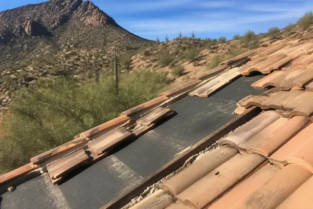 Repairing clay roof tiles over waterproof underlayment at a worksite in Tanque Verde, AZ.