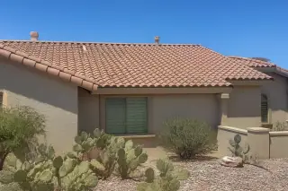 Finished clay tile roof repair with stucco walls and prickly pear cactus in a yard in Tucson, AZ.