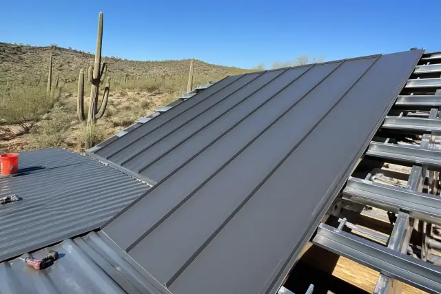 Western Rib and PBR metal roofing panels being installed on a sloped roof in the Tucson, AZ desert.