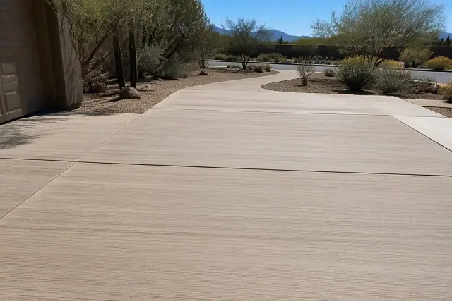 Broom-finish concrete overlay on a residential driveway in Tucson, AZ, with Sonoran desert landscaping in the background.
