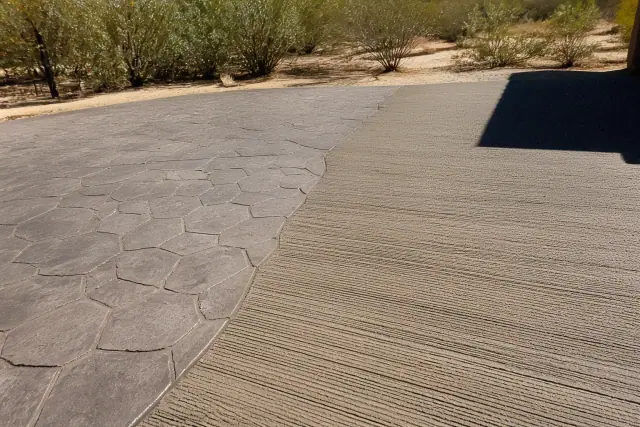 Broom overlay next to a stamped concrete finish with creosote bushes in the background in Tucson, AZ.