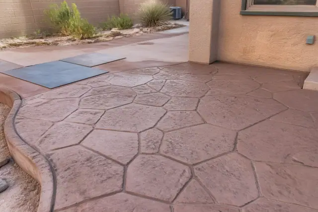 Colored and stained concrete patio with stone patterns and desert landscaping in the background in Tucson, AZ.