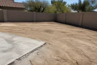 Clean-cut concrete slab edge on a cleared pool deck footprint with caliche soil and stucco walls in Tucson, AZ.