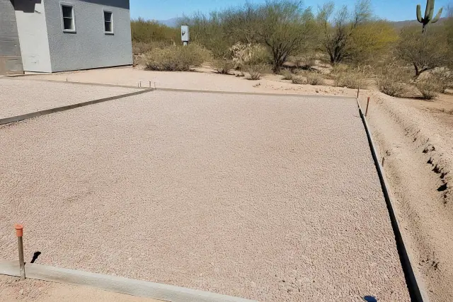 Gravel base prepared for a concrete driveway installation in the Sonoran desert of Marana, AZ.