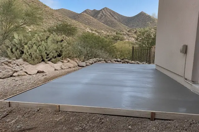 Finished concrete patio inside wooden forms with Sonoran Desert xeriscaping and mountain views in Oro Valley, AZ.