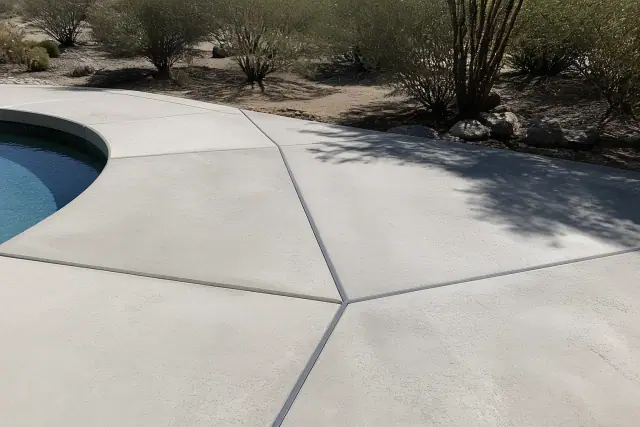 Concrete pool deck expansion joints with flexible filler in Vail, AZ, under bright desert sun.
