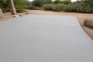 Smooth resurfaced concrete driveway with prickly pear cacti and desert gravel in Tucson, AZ.