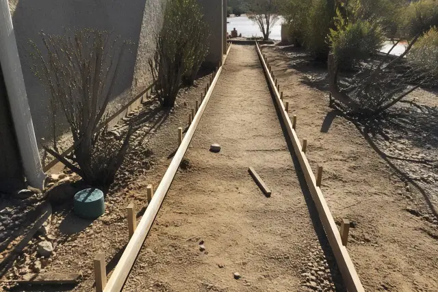 Wooden forms and stakes set up for a new concrete sidewalk project in Drexel Heights, AZ.