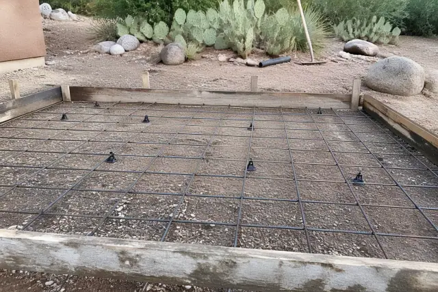 Steel wire grid on plastic spacers for a concrete pour at a worksite with cacti in Tucson, AZ.