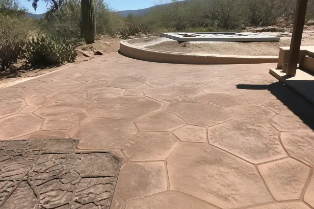Stamped concrete with stone patterns in a Tanque Verde, AZ landscape with desert cacti and harsh sunlight.