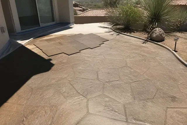 Technician stamping a stone-like pattern into fresh concrete at a residential jobsite in Green Valley, AZ.