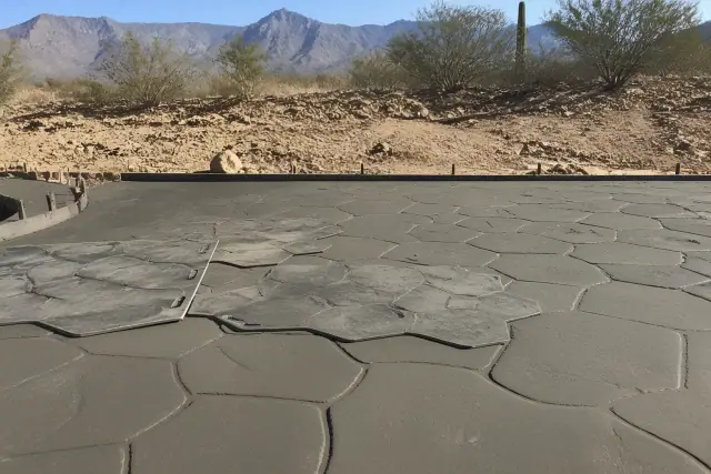 Stamped concrete with stone-like textures on a jobsite in Marana, AZ, featuring desert vegetation in the background.