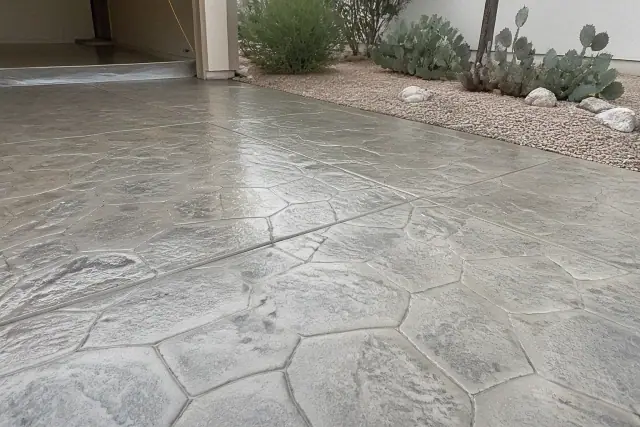Stamped concrete overlay showing stone patterns with cactus and granite landscaping at a residential site in Tucson, AZ.