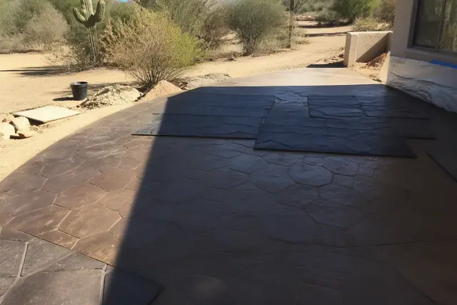 Stamped concrete patio work-in-progress with textured patterns and desert landscaping in Tucson, AZ.