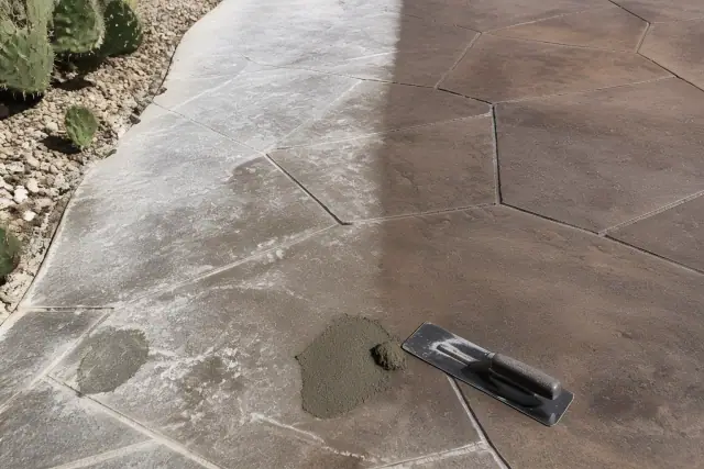 Stamped concrete restoration with a bonding compound next to prickly pear cactus and gravel in Tucson, AZ.