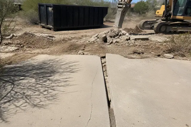 Wide crack beside a settled driveway panel during a concrete removal project in Tucson, AZ.