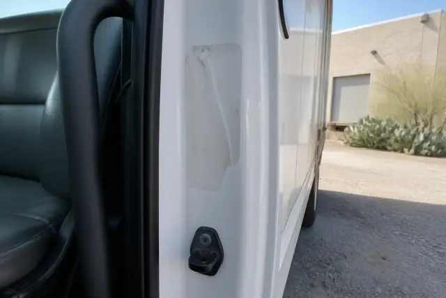 Close-up of a missing GVWR sticker on a box truck door jamb at an industrial site in Tucson, AZ.