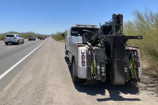 Secure straps and equipment on a heavy duty tow truck parked on a gravel highway shoulder in Tucson, AZ.