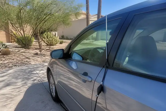 Technician using a lockout tool to open a car door in a Tucson, AZ driveway.
