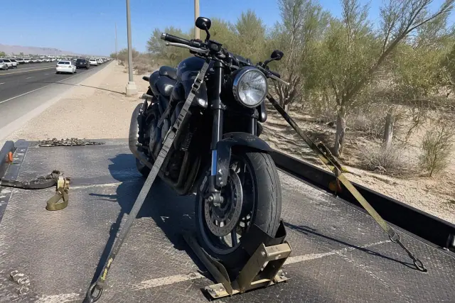 Motorcycle secured with chocks and soft ties on a flatbed truck in the desert near Tucson, AZ.