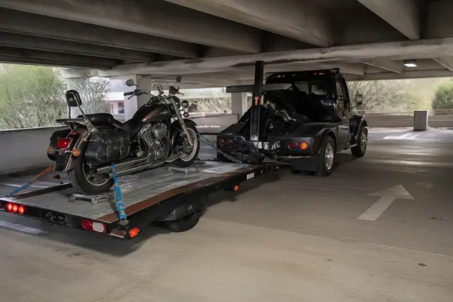 Motorcycle secured with ratchet straps on a trailer in a concrete parking garage in Catalina Foothills, AZ.