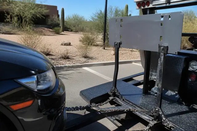 A blank legal-code stencil resting on sign-mount brackets on sun-bleached asphalt with saguaros in Tucson, AZ.