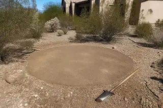 Cleared desert ground with smoothed soil where a cactus was removed in Tucson, AZ.
